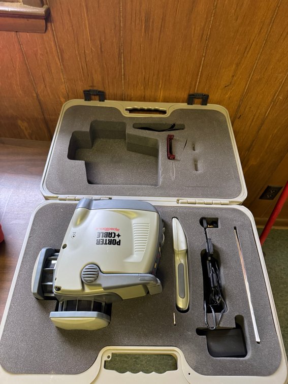 Porter Cable laser level in protective carrying case with accessories and power adapter.