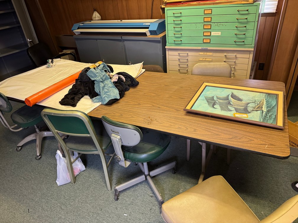 Assorted drafting/office materials including large rectangular table with chairs