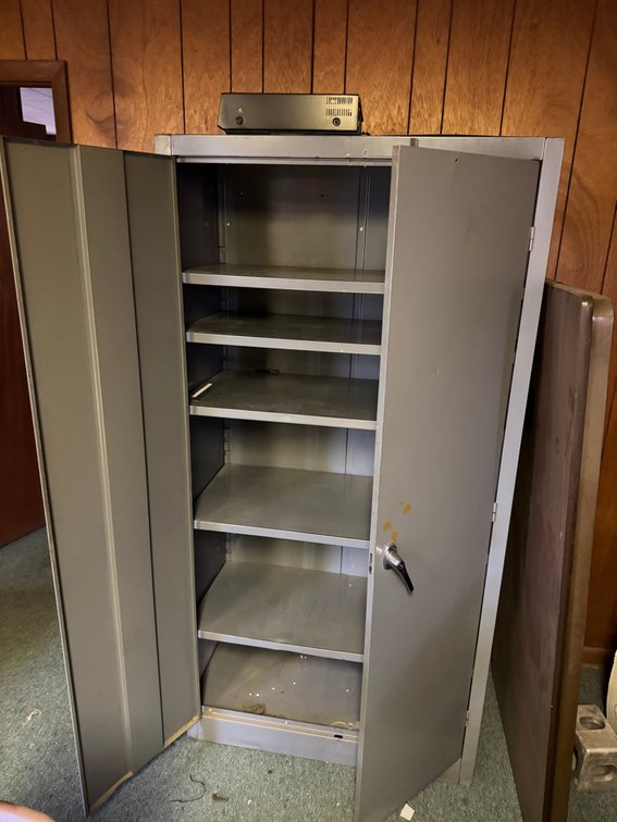 Tall gray metal storage cabinet with double doors, lockable handle, and multiple interior shelves.
