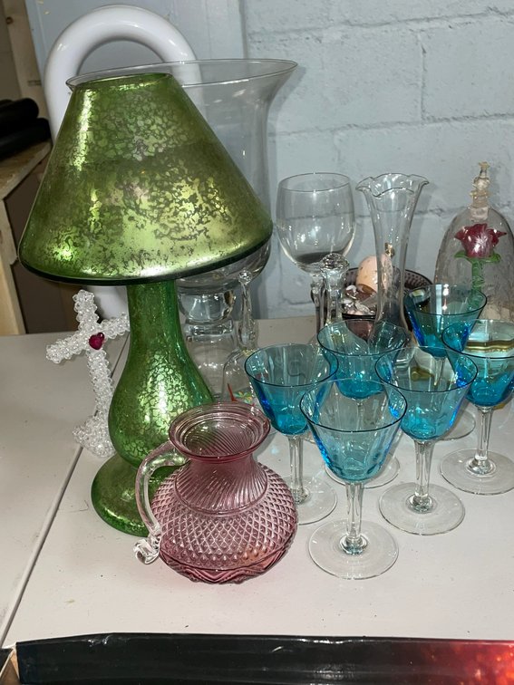 Blue stemware with clear bases, clear vase, small pink pitcher, green candleholder