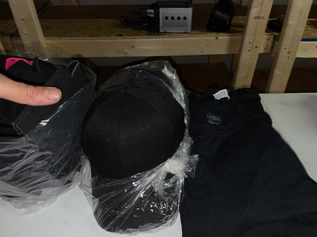 Collection of various sizes of black t-shirts-sizes vary from child's to adults, black hats, black koozies