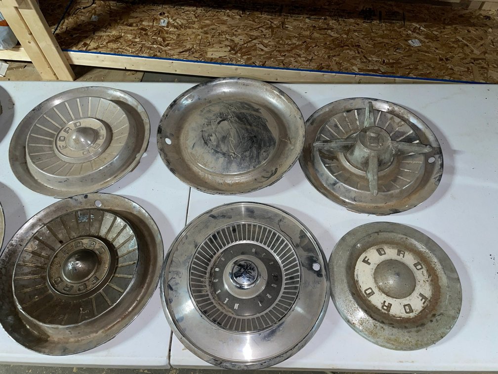 Selection of antique automotive hubcaps-various makes and models