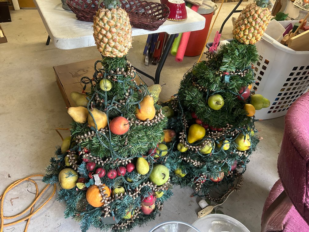 2 Christmas trees covered in faux fruit