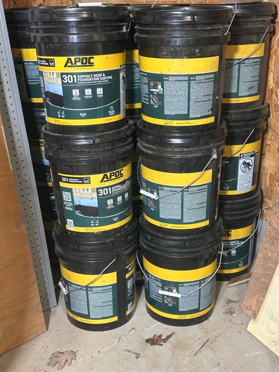 Several 5 gallon buckets of APOC asphalt, roof and foundation coating