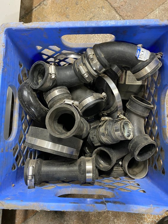 MILK CRATE OF RUBBER PIPE COUPLERS WITH HOSE CLAMPS