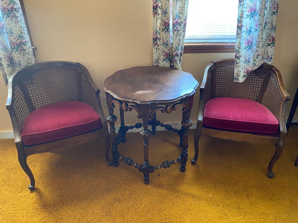 Round table with decorative legs with 2 rattan style back chairs and cushion bottoms