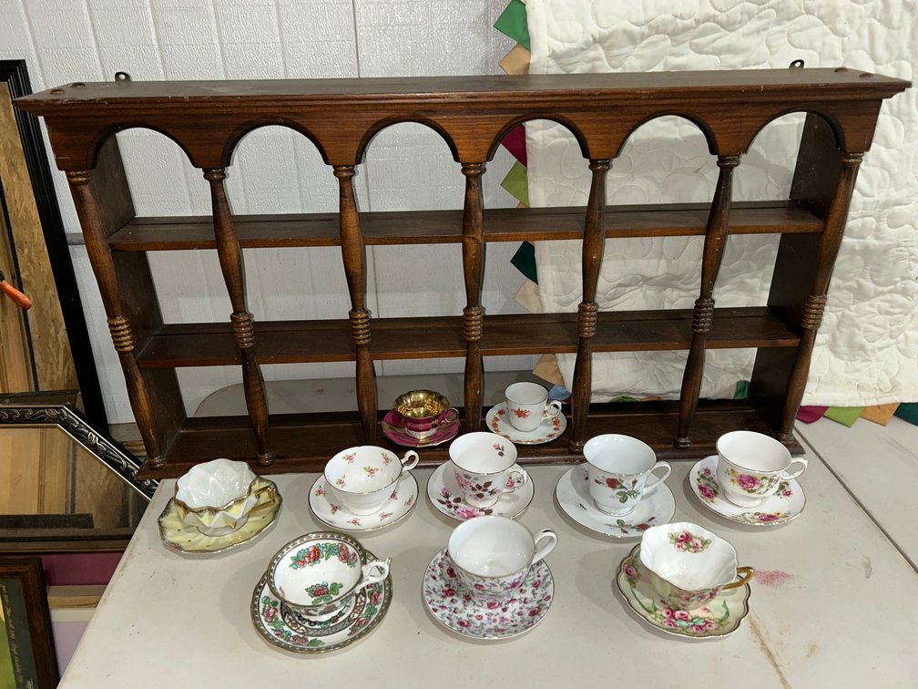Collection of porcelain teacups with display shelf