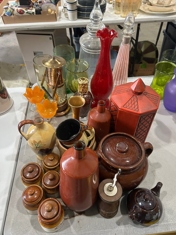 Brown wine bottle with black trim, bean pot, canister, red fluted vase, other decorative items