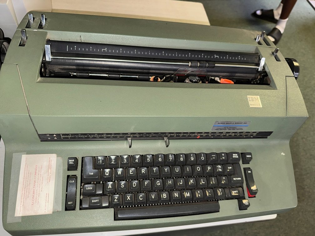 Vintage IBM electric typewriter with full keyboard and heavy-duty metal housing.