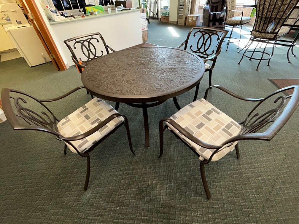 Tropitone Palladian double-c cast seat dining chairs with seat pads and Arezzo 49" round cast dining table