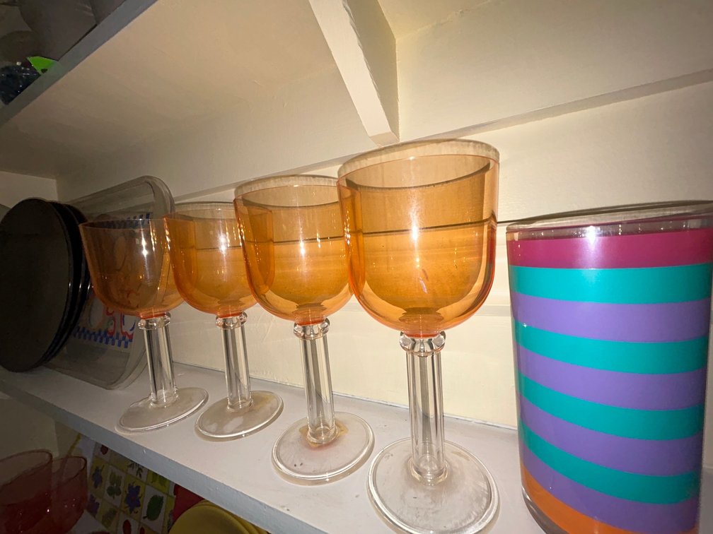 Fruit tray, 4 orange goblets, 3 black plates, 3 striped tumblers