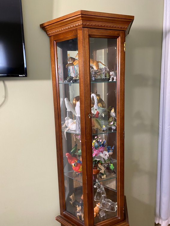 Lighted curio cabinet with contents of birds, flowers, tigers