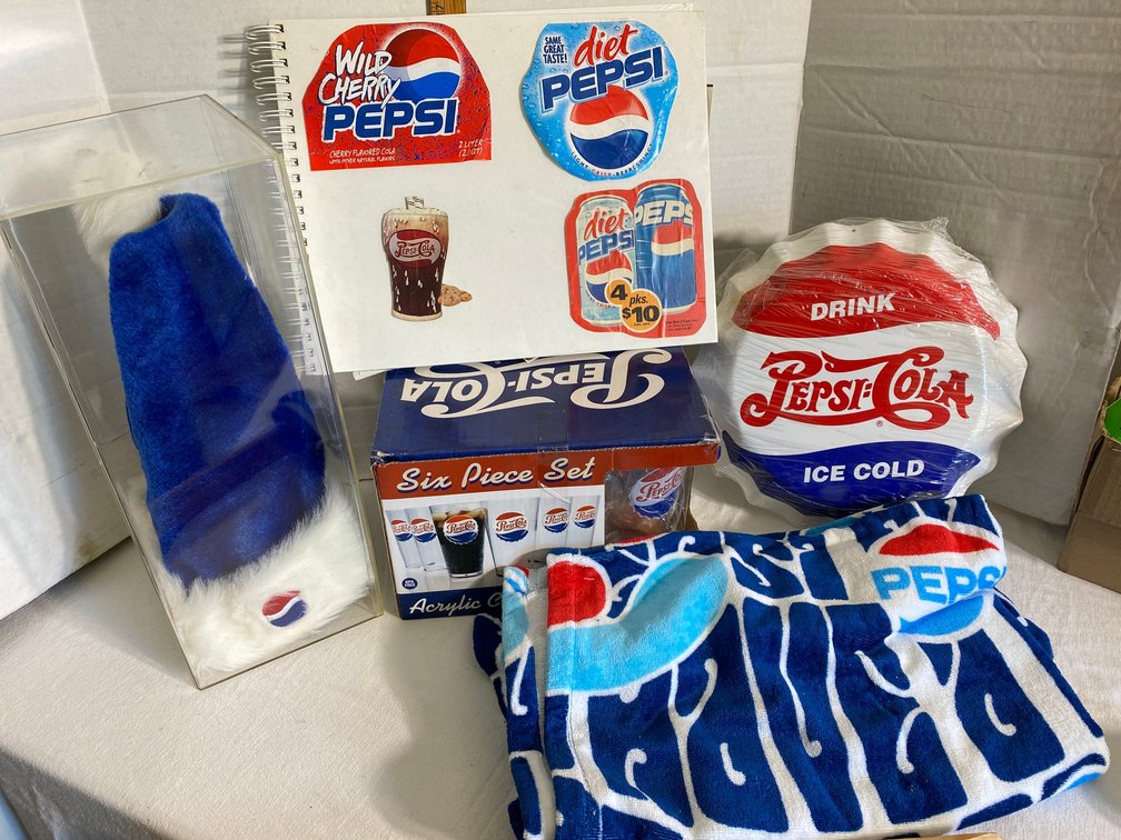 Pepsi-Cola collectibles-scrapbook, hat in display case, 6 piece set of drinking cups, tin sign shaped like a bottle cap, towel