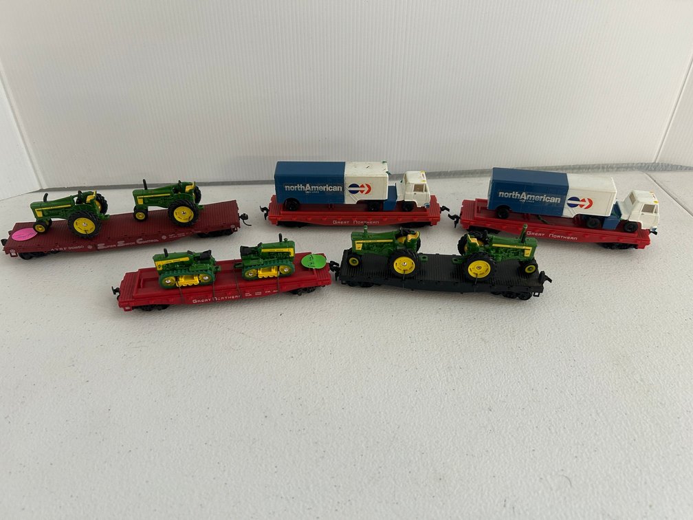 Selection of HO Scale flat cars with contents