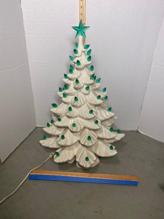 White ceramic Christmas tree with lighted base and green bulbs