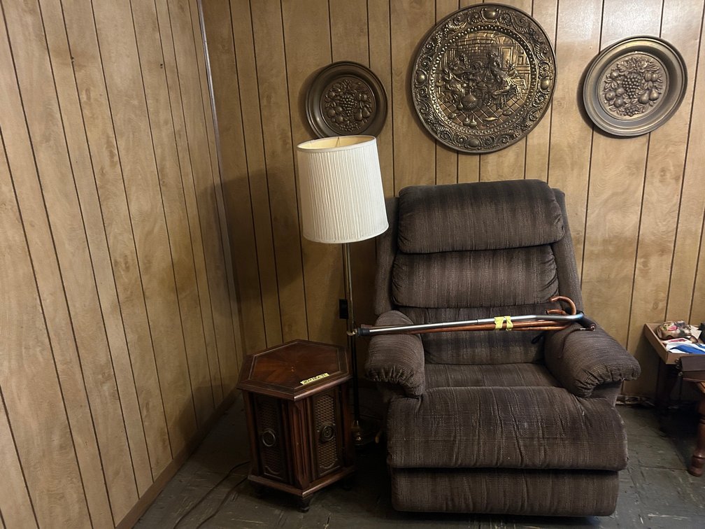 Grouping of recliner, round decorative wall hangings, floor lamp, side table