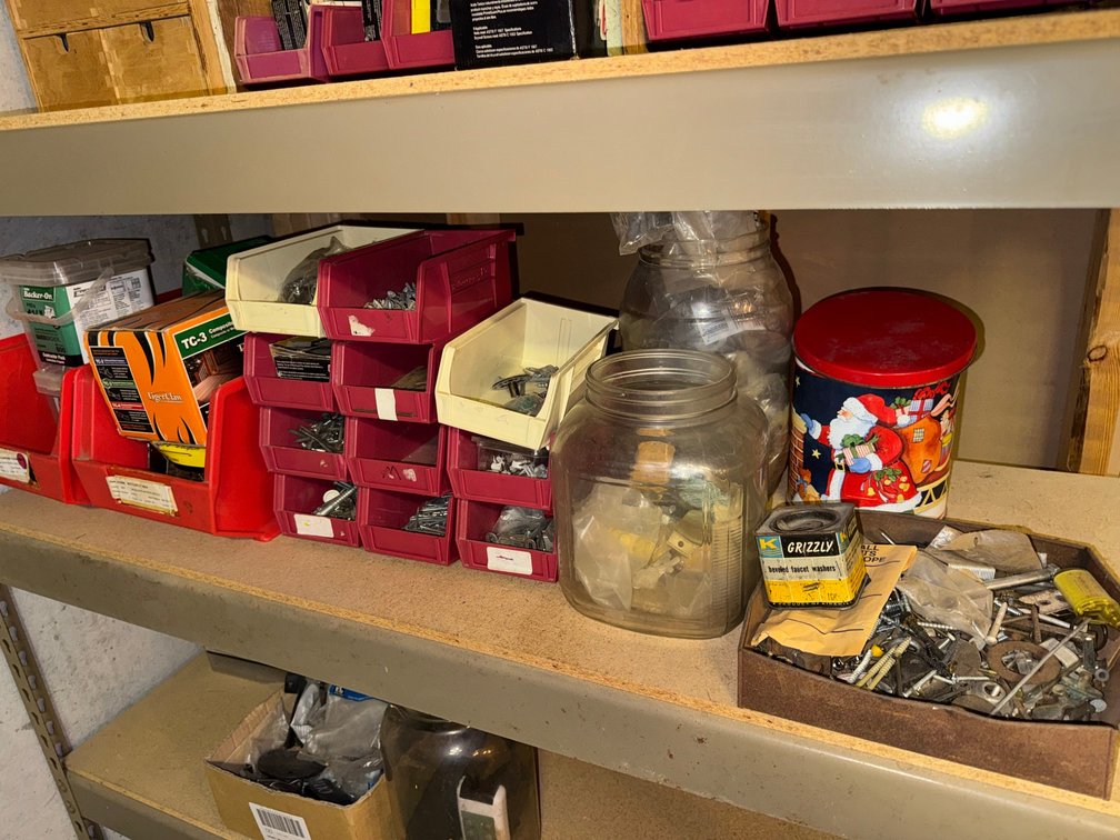 Plastic bins containing assortment of screws, nails and other fasteners