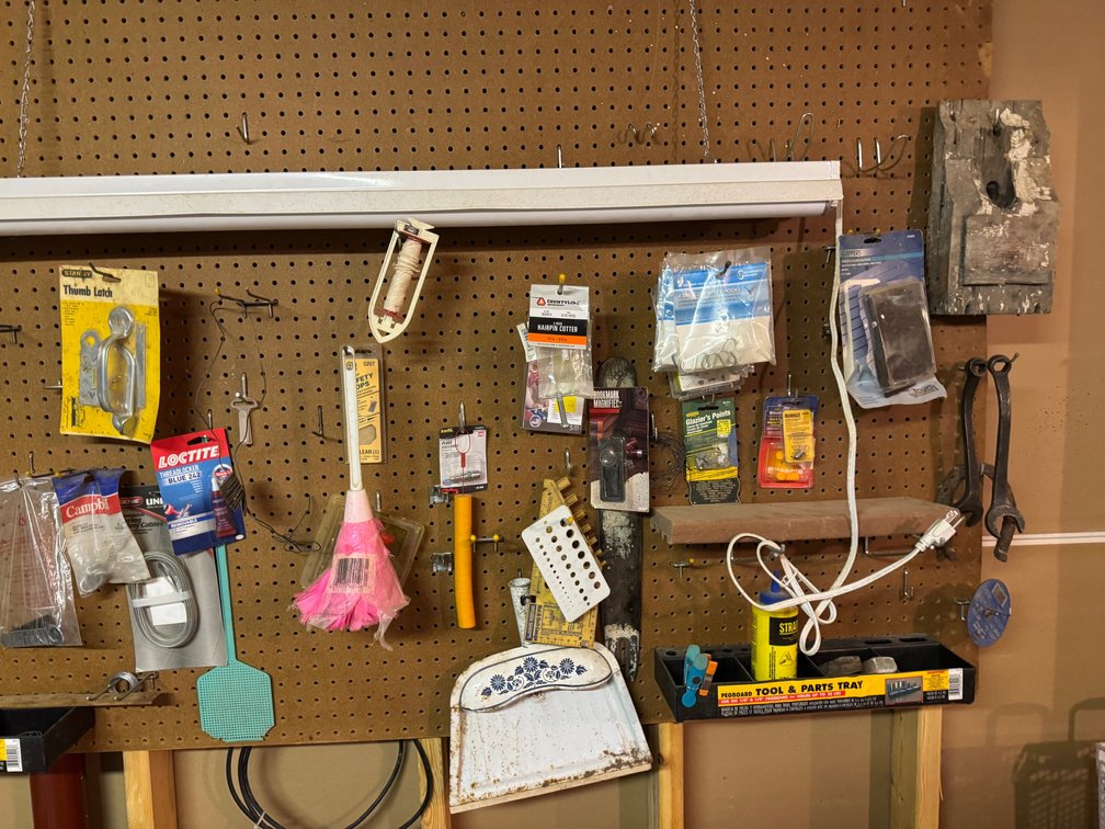 Pegboard organization system featuring mounted 4' LED shop light, other various items