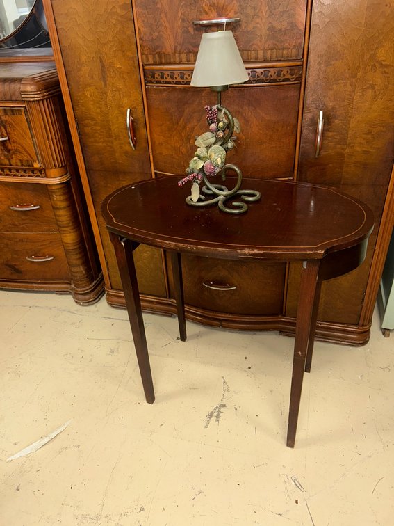 Small oval table with wear and small decorative lamp