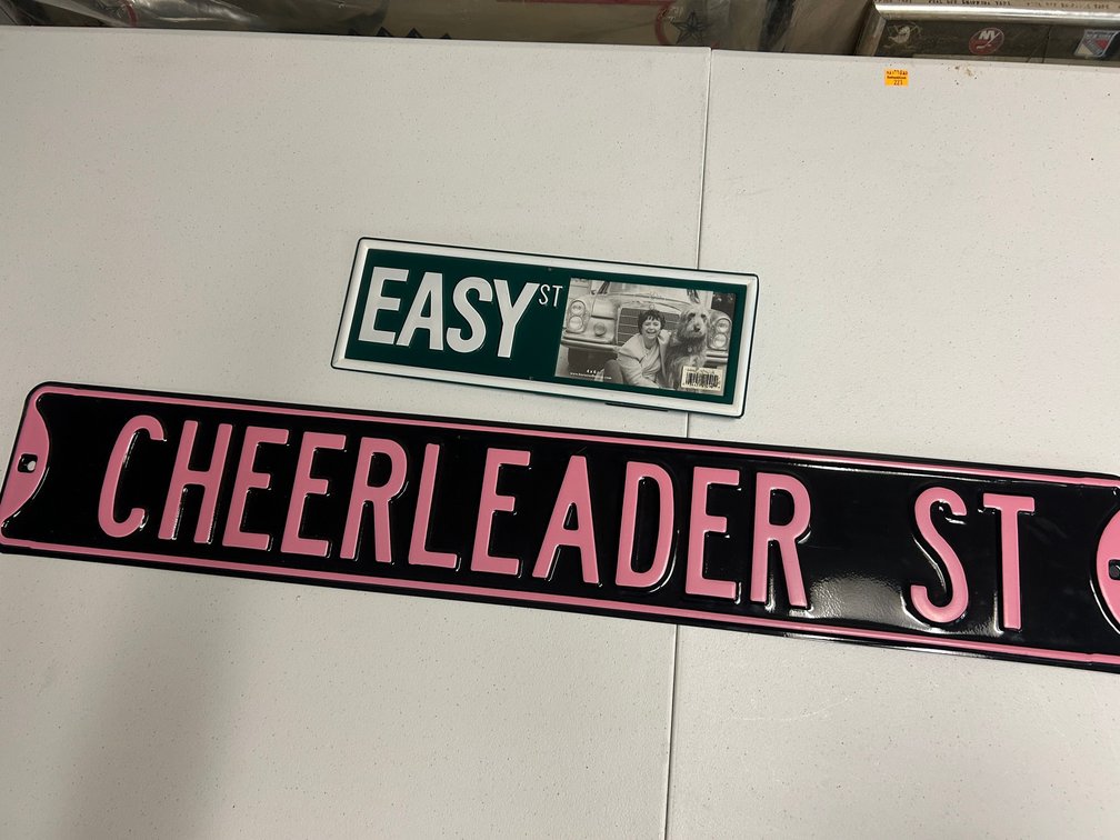 Decorative street signs reading 'Cheerleader Street' and 'Easy Street'