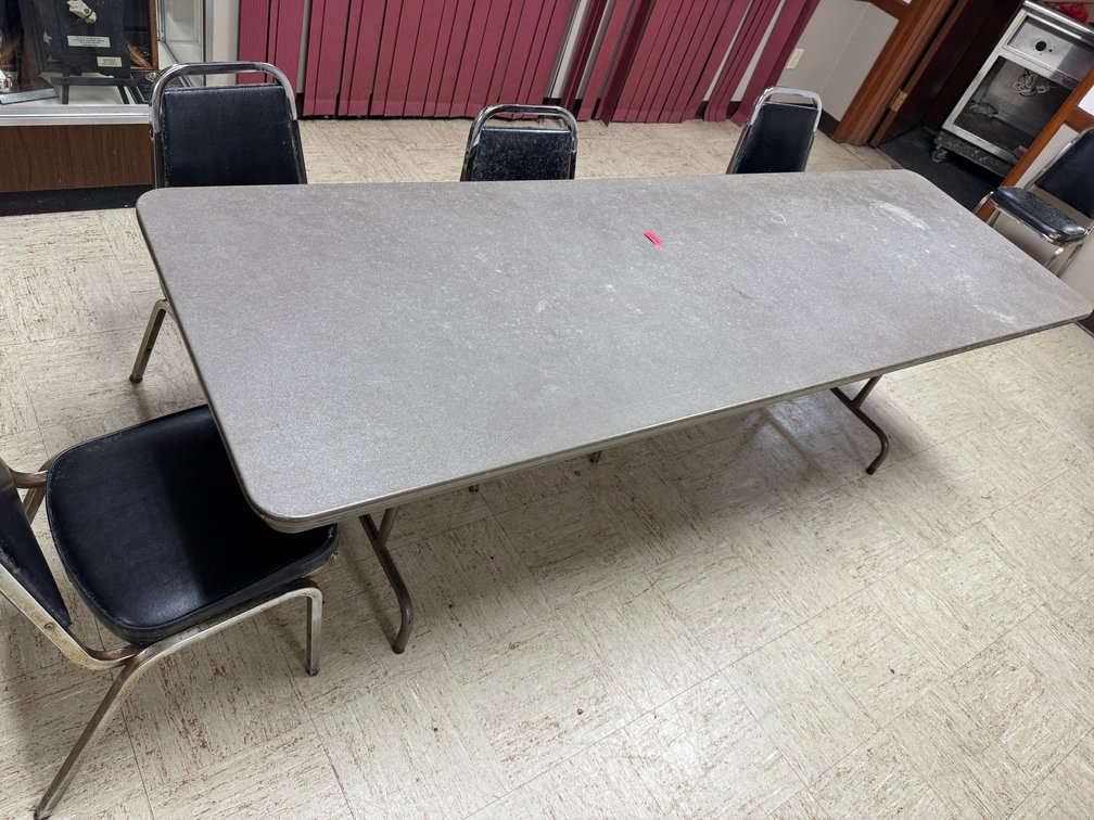 Rectangular banquet tables with black chairs