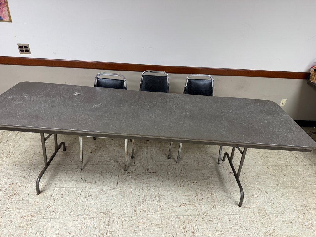 Rectangular banquet tables with black chairs