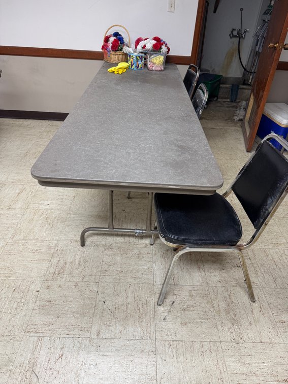 Rectangular banquet tables with black chairs