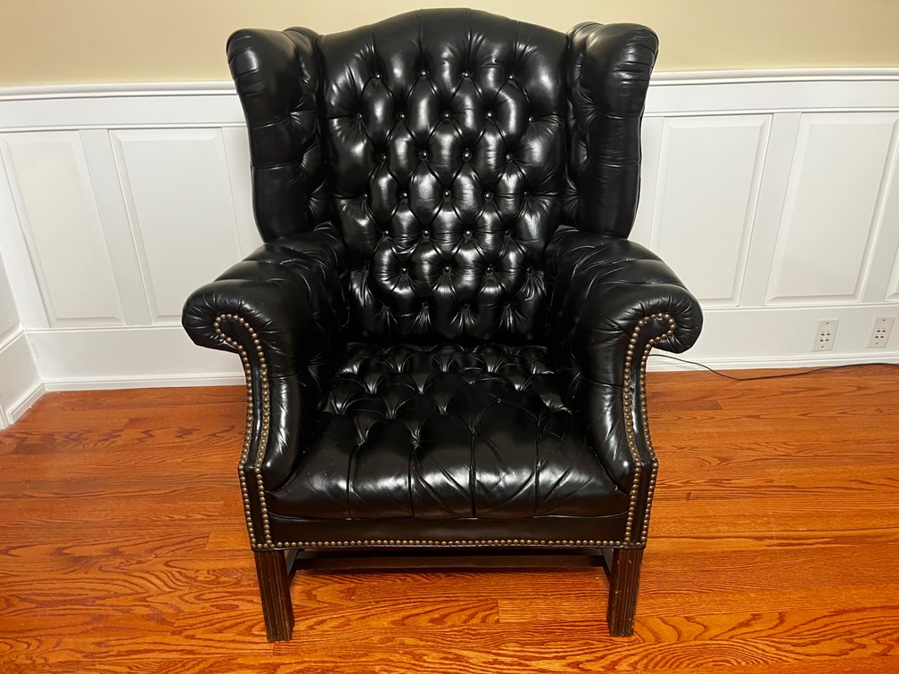 A Tufted Black Leather Wingback Armchair