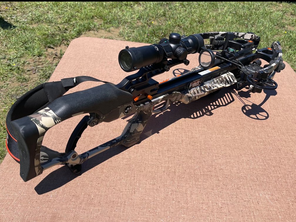 Ravin R10 crossbow in Predator camouflage featuring a mounted scope. Includes carrying case filled with extra accessories!