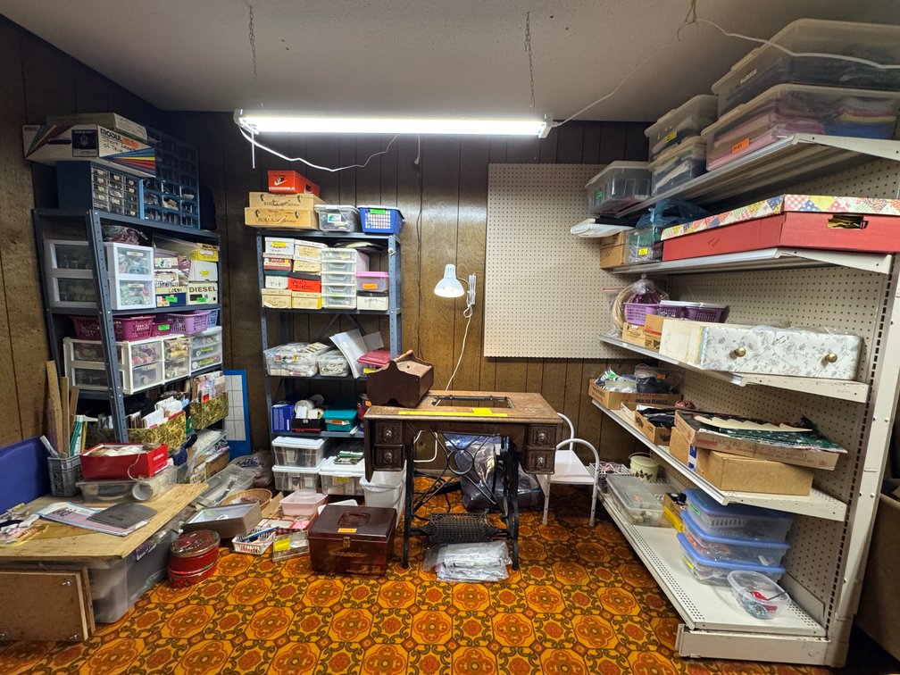Contents of North basement wall, sewing, fabric, material, misc. craft materials, vintage treadle sewing machine stand- no top