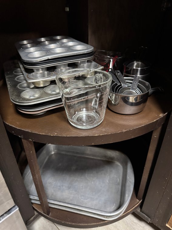 contents of lazy susan, drawers, and cabinet, pans, measuring, rags, etc.