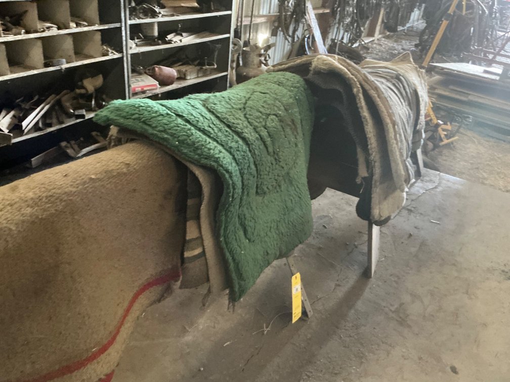 Approximately (13) Assorted Used Saddle Blankets and Pads with (2) Saw Horses