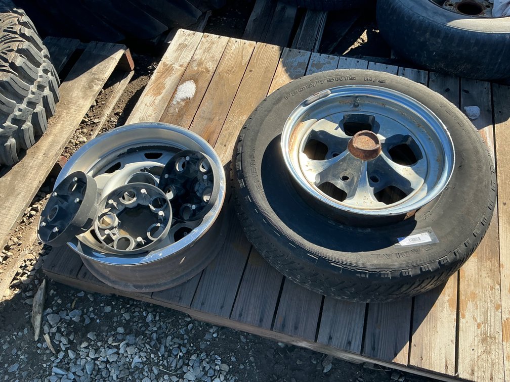 (1) P205/75R15 Tire On 5-Lug Steel Wheel - Poor Tread, (1) 5-Lug Steel Wheel, And (3) 5-Lug Plastic Chevrolet Wheel Lug Covers