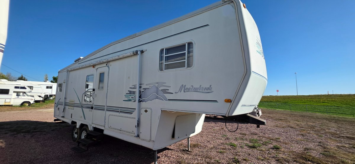 2000 Meadowbrook with 16 ft awning, tires fair, 2-30 lb propane tanks, single slide 12', hard sided, interior appears okay, needs a little work but could be a usable camper