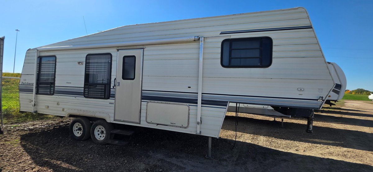 1993 Dutchman Classic 280 5th wheel camper with gooseneck hitch, 18' awning, rear receiver hitch, 2 - 30# LP tanks, hail damage, tires fair, water damage in rear, needs work