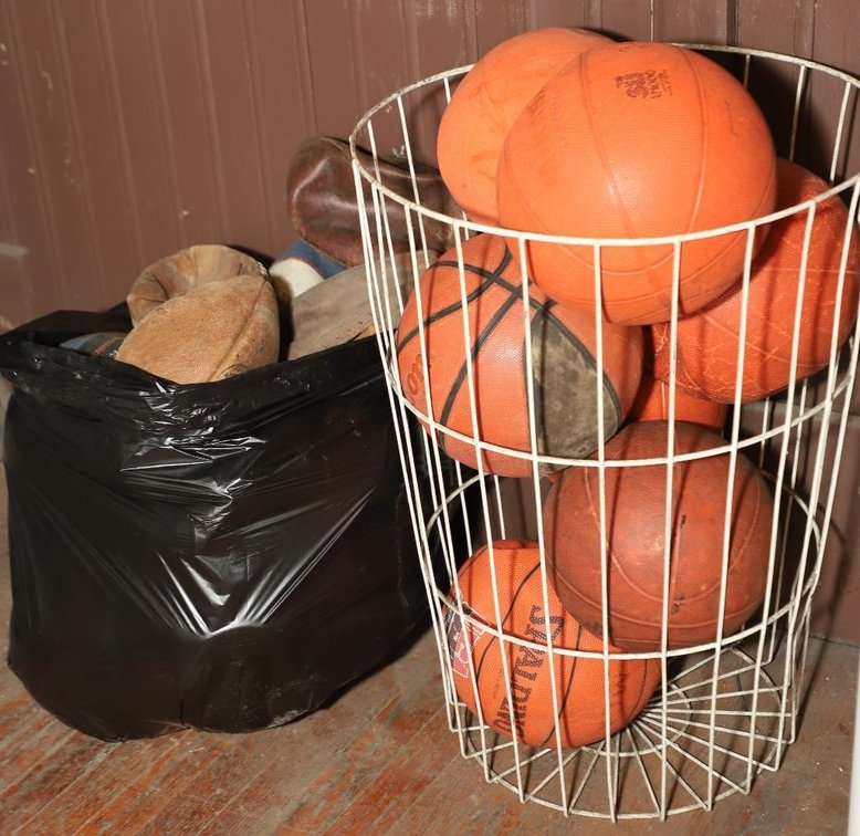 Wire Basket with Deflated Footballs and Basketballs