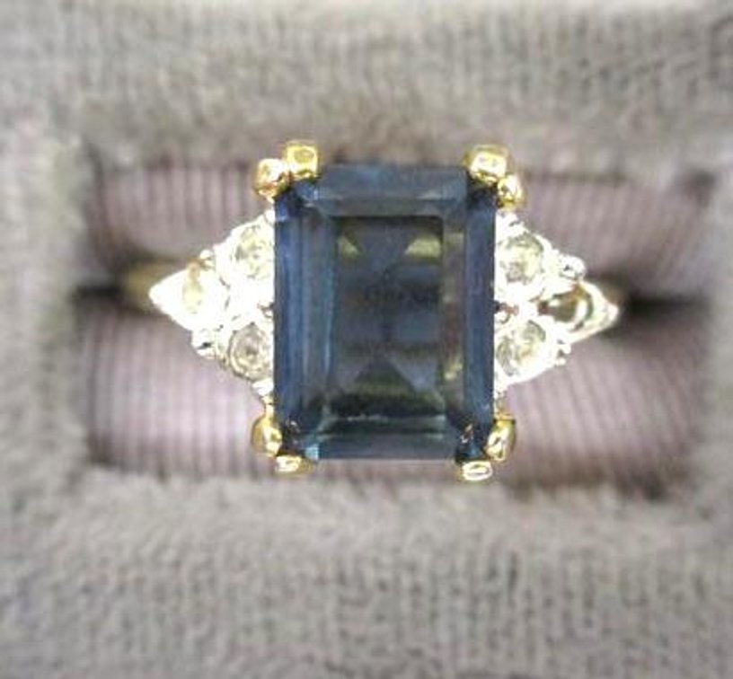 18kt Gold plated emerald cut blue sapphire ring with clear accent stones, missing a stone