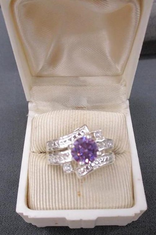 Inner marked NRO silver tone ring with purple center stone and cz accents
