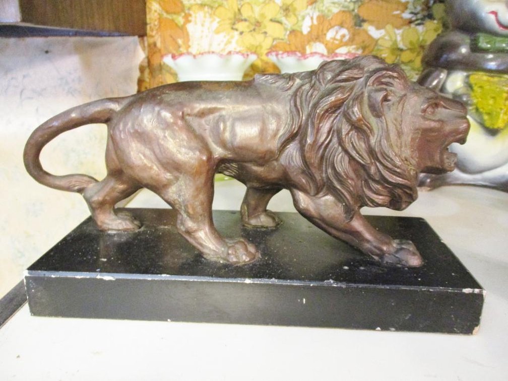 Cast metal lion on plaster base