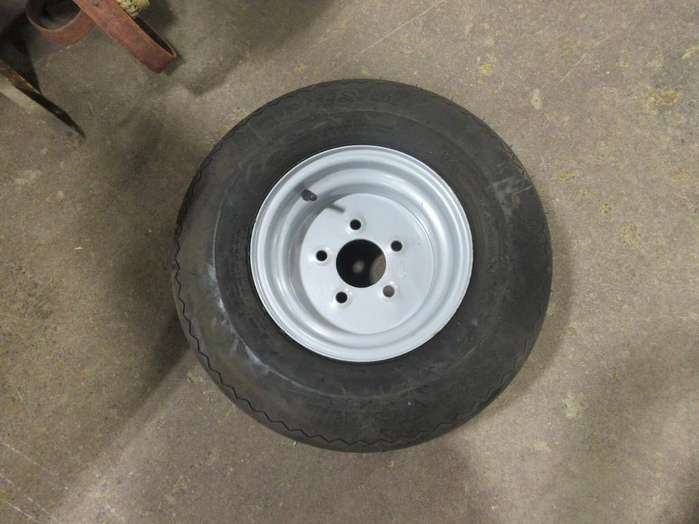 Near new small trailer tire on 5-bolt rim