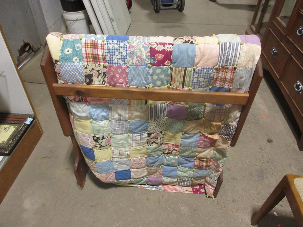 Pine quilt rack with hand tied pieced quilt