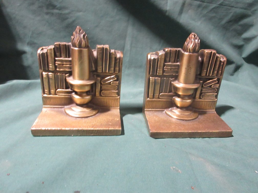 Pair of cast metal book and candle bookends