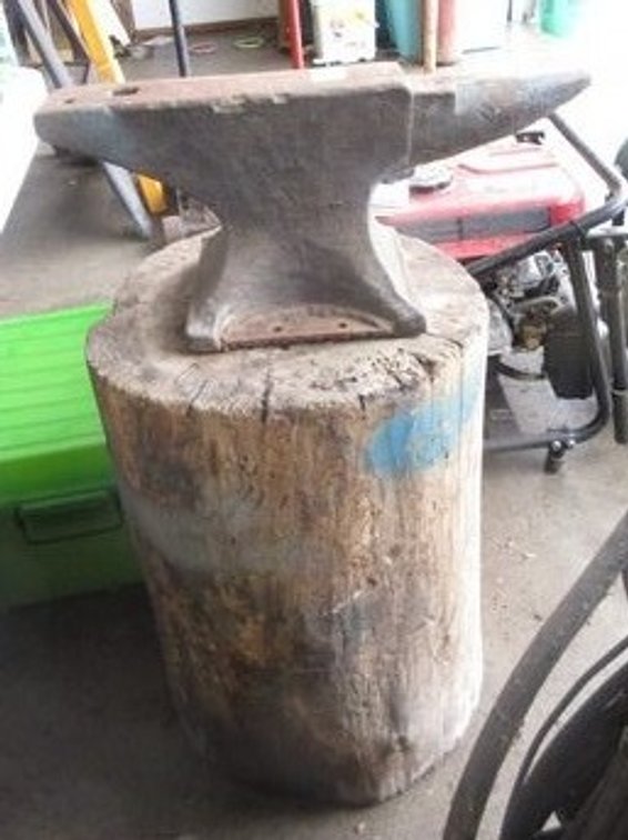 Anvil on wood log