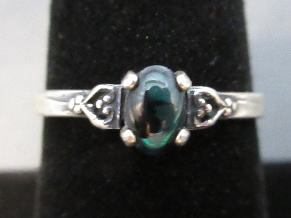 Unmarked silver colored ring with  dark green stone
