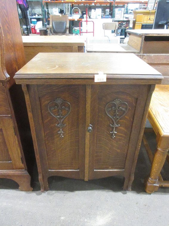 Antique treadle sewing machine in ornate oak cabinet