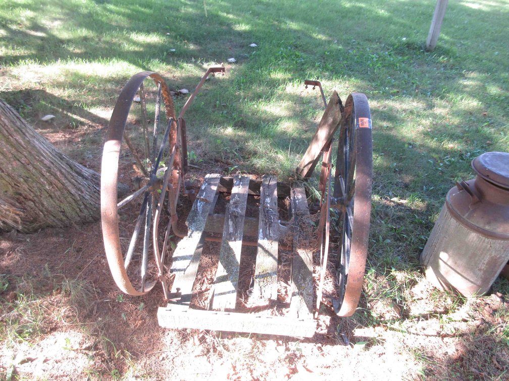 Antique milk can cart with steel wheels