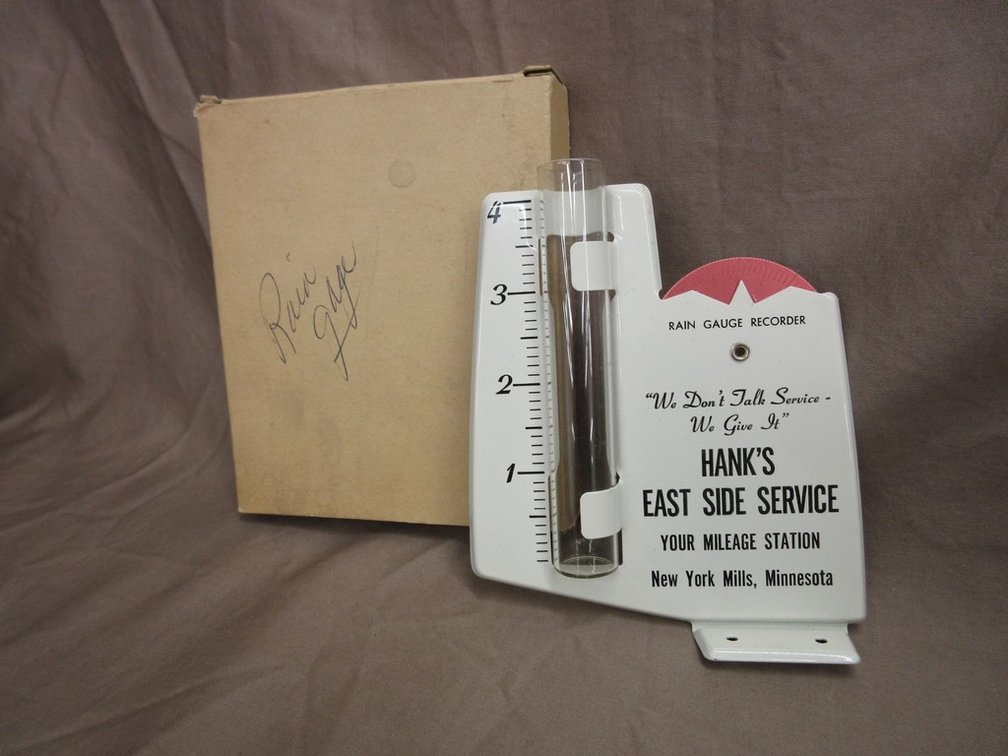 "Hank's East Side Service", New York Mills, Minnesota advertising pressed metal rain gauge
