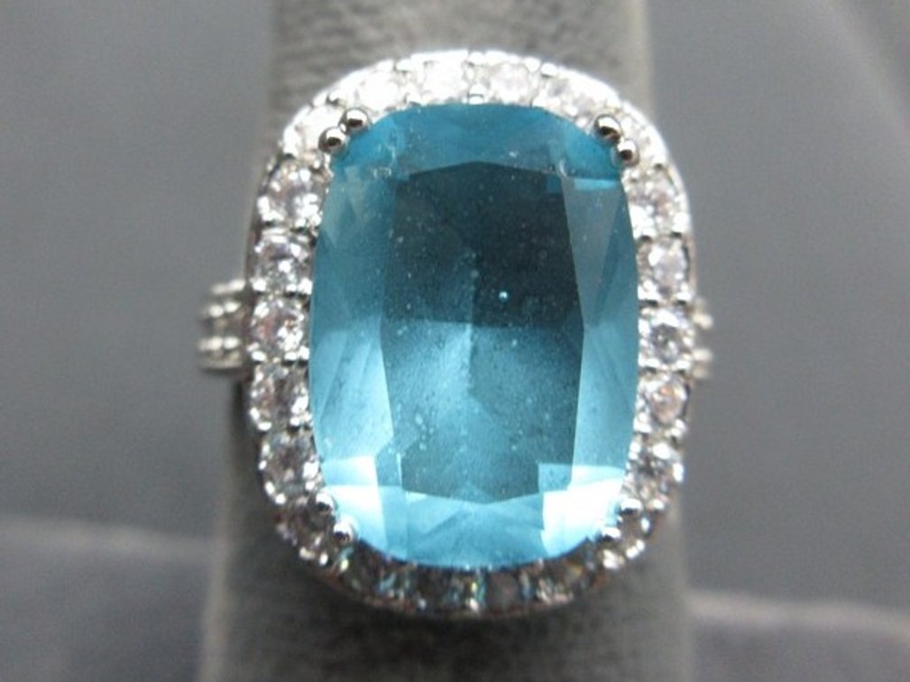 Marked .925 silver ring with large light blue stone and small clear stones