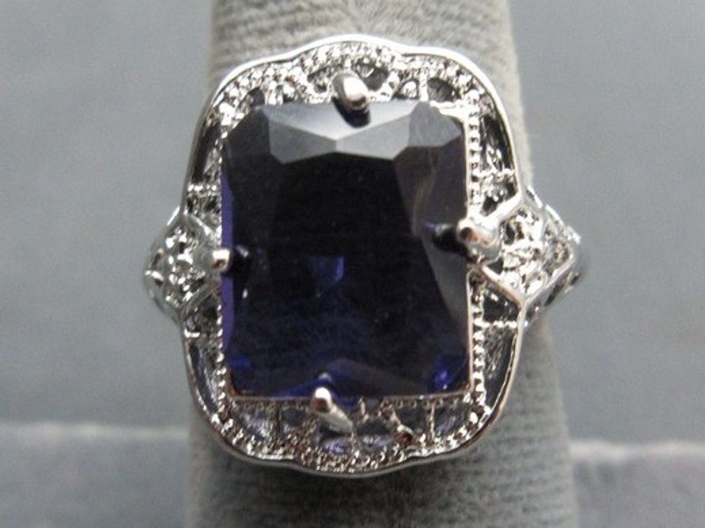 Unmarked silver-tone filigree band with large amethyst-colored stone