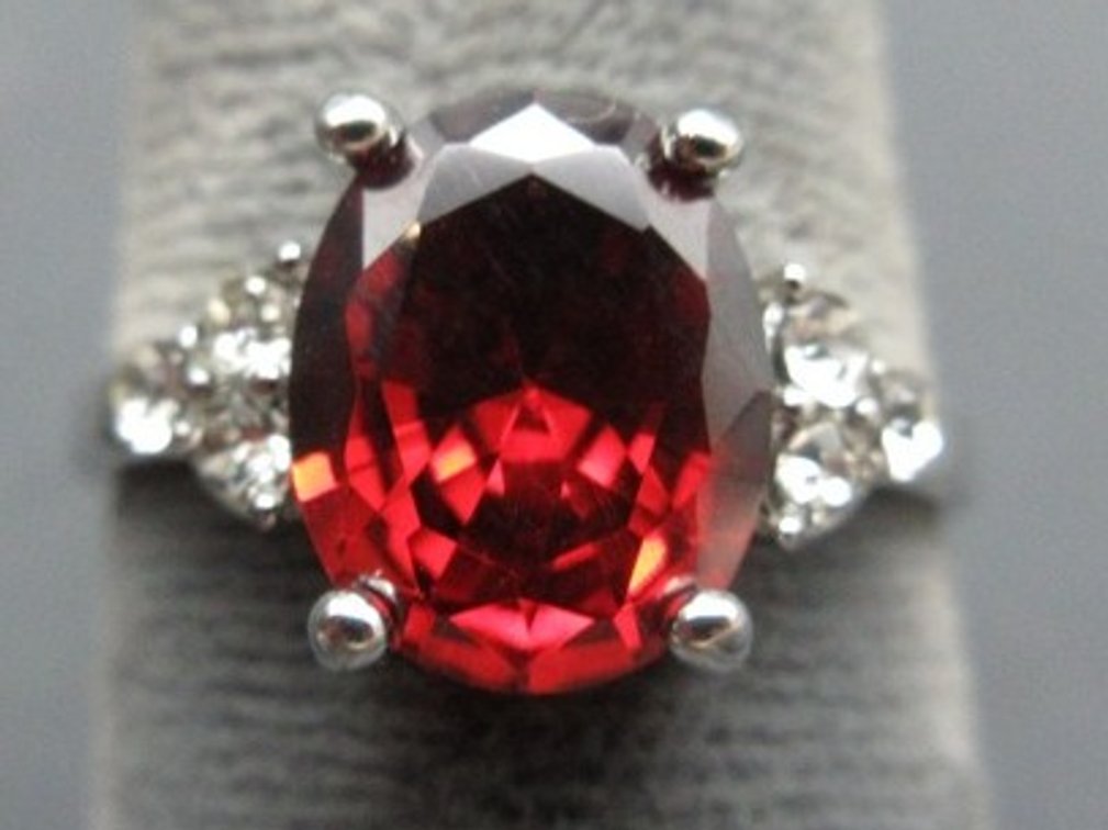 Unmarked silver-tone ring with ruby-colored stone